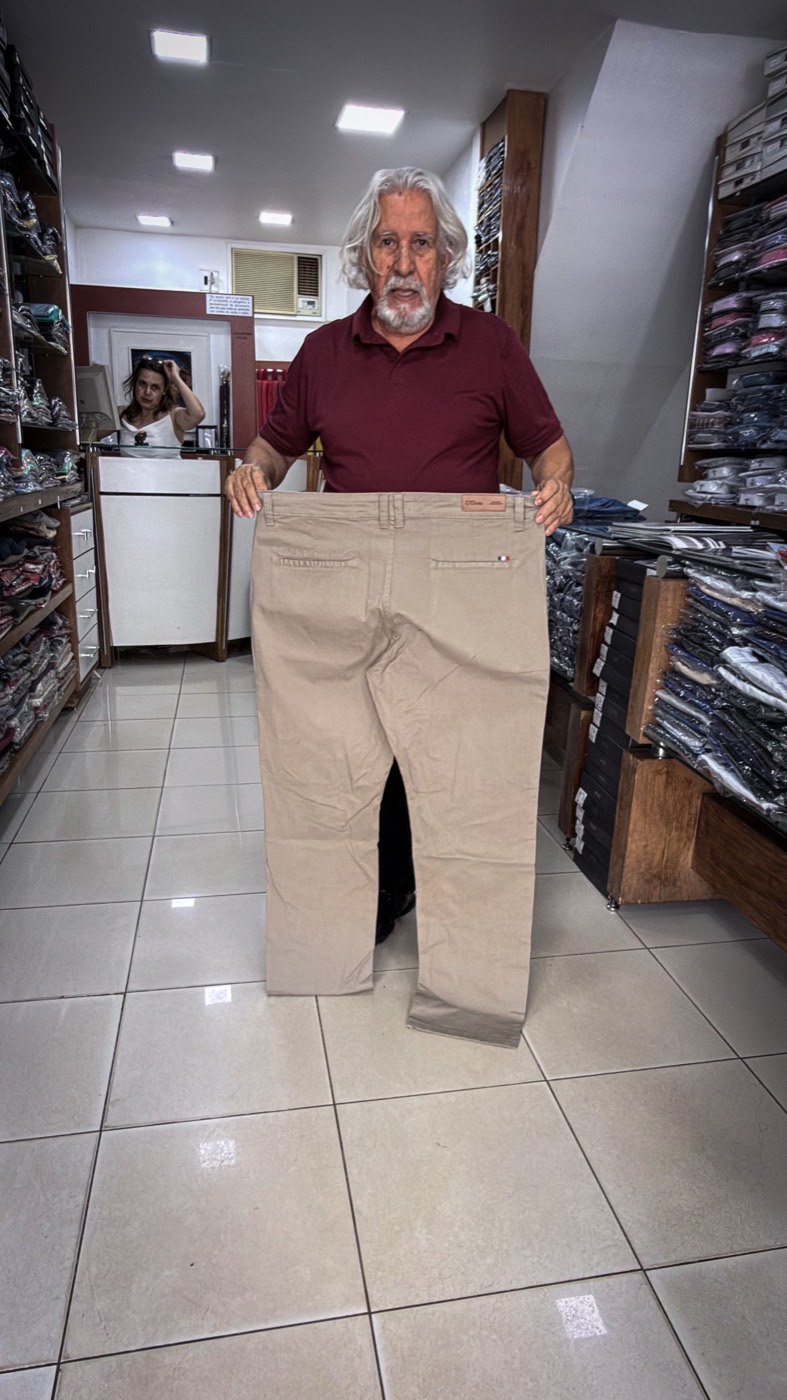 Vendedor exibindo calça masculina plus size em tamanho especial