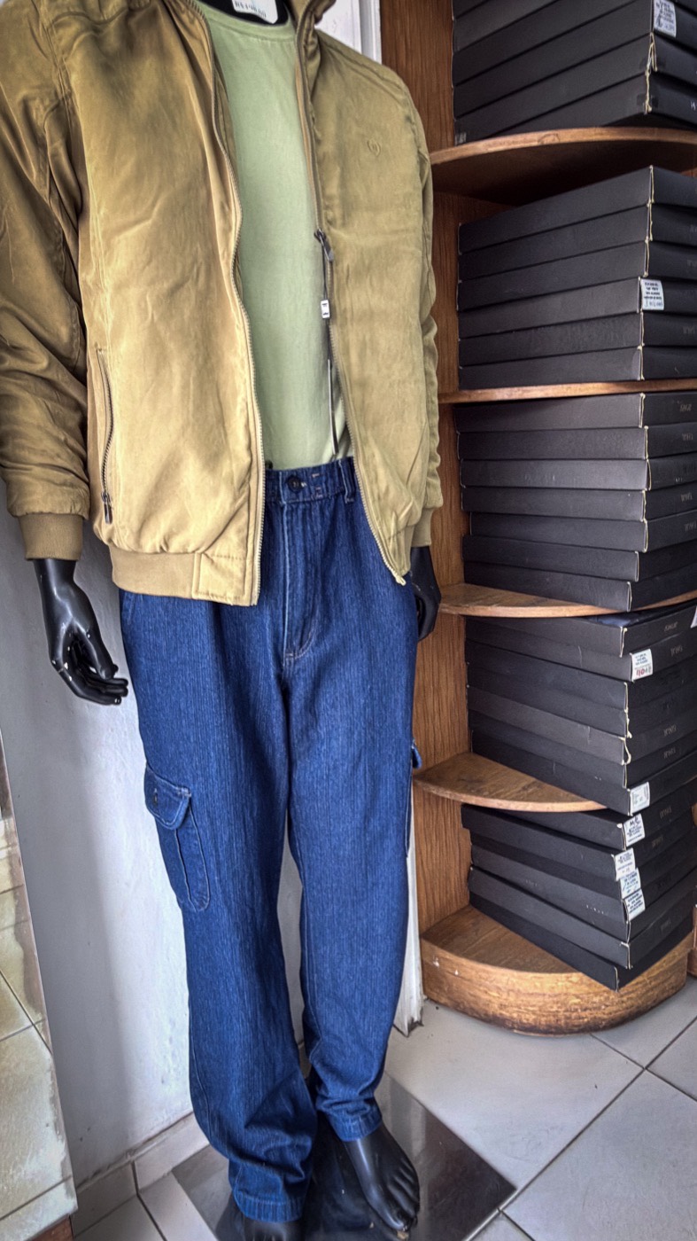 Manequim com jaqueta caqui, camiseta verde e calça jeans cargo