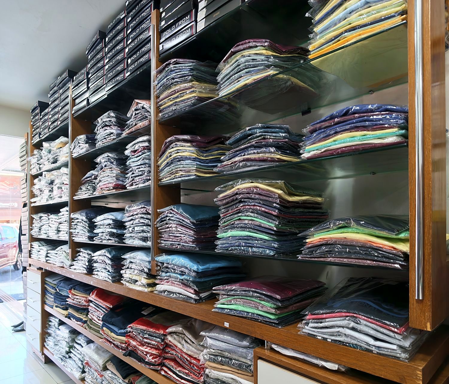 Parede de polos e camisetas coloridas em tamanhos variados, incluindo plus size
