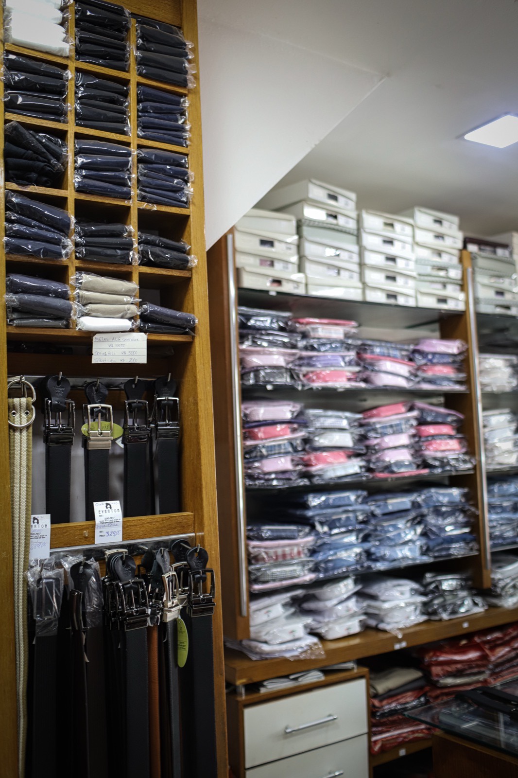 Prateleiras repletas de camisas masculinas dobradas de diversas cores e estampas
