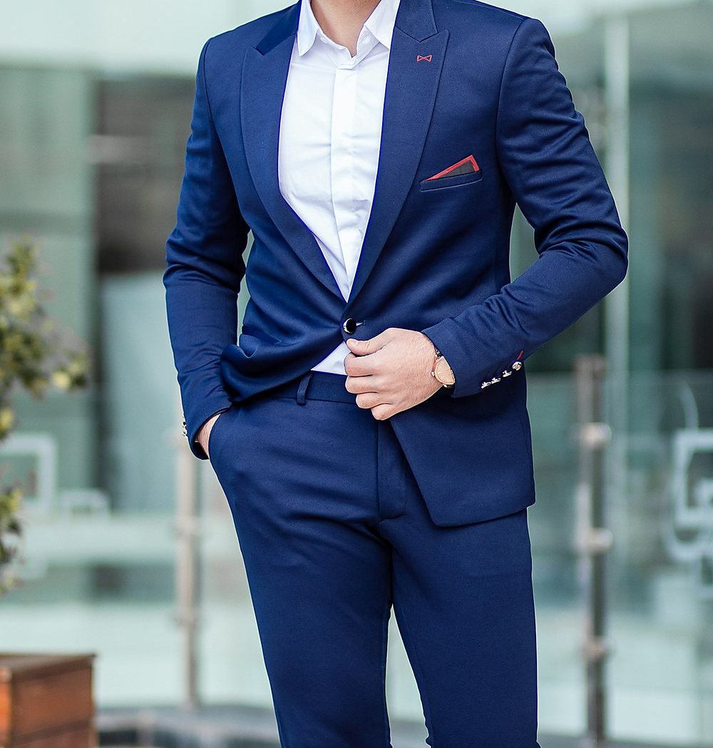 Terno azul-marinho slim de alfaiataria com camisa branca e lenço no bolso